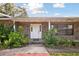 Charming brick home featuring a welcoming front door framed by lush landscaping and classic architectural details at 949 Shadow Oaks Rd, Kissimmee, FL 34744