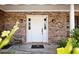 Classic brick house with a white front door flanked by sconces and decorative greenery at 949 Shadow Oaks Rd, Kissimmee, FL 34744