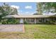 Charming one-story brick house with mature landscaping, spacious lawn, and a concrete driveway and walkway at 949 Shadow Oaks Rd, Kissimmee, FL 34744