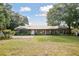 Well-maintained ranch-style house featuring mature landscaping, a metal roof, and a serene outdoor setting at 949 Shadow Oaks Rd, Kissimmee, FL 34744