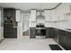 Modern kitchen features stainless steel appliances, quartz countertops, and updated white and gray cabinetry at 949 Shadow Oaks Rd, Kissimmee, FL 34744