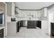 Modern kitchen features stainless steel appliances, quartz countertops, and updated white and gray cabinetry at 949 Shadow Oaks Rd, Kissimmee, FL 34744