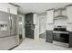 Kitchen features stainless steel appliances, quartz countertops, and updated white and gray cabinetry at 949 Shadow Oaks Rd, Kissimmee, FL 34744