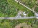 Bird's-eye view of the property with a circular driveway and various structures surrounded by lush greenery at 9506 Number Two Rd, Howey In The Hills, FL 34737