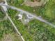 Aerial perspective captures the property's layout near a road, complemented by surrounding trees and structures at 9506 Number Two Rd, Howey In The Hills, FL 34737