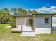 Exterior view showcasing a small deck with steps and sliding door, side of home and yard at 9506 Number Two Rd, Howey In The Hills, FL 34737