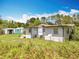 Exterior view of home showcasing the yard and utility buildings in the background at 9506 Number Two Rd, Howey In The Hills, FL 34737