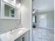 This half-bathroom features tile flooring and a vanity with a marble countertop at 9506 Number Two Rd, Howey In The Hills, FL 34737