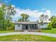 Charming one-story home featuring front porch and ample greenery surrounding the property and long driveway at 9506 Number Two Rd, Howey In The Hills, FL 34737