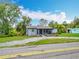 Charming one-story home with inviting front porch, ample greenery, and long gravel driveway at 9506 Number Two Rd, Howey In The Hills, FL 34737