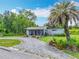 Charming one-story home featuring front porch, ample greenery, and unique circular gravel driveway at 9506 Number Two Rd, Howey In The Hills, FL 34737
