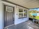 Enclosed front porch with a decorative door, light fixture, and view of the yard and blue storage shed at 9506 Number Two Rd, Howey In The Hills, FL 34737