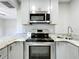 A kitchen with stainless steel appliances, granite countertops, and grey cabinets at 9506 Number Two Rd, Howey In The Hills, FL 34737