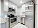 Updated kitchen features stainless steel appliances, grey cabinets, and granite countertops at 9506 Number Two Rd, Howey In The Hills, FL 34737