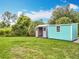Turquoise and grey storage sheds offer ample space and convenience on a grassy lawn at 9506 Number Two Rd, Howey In The Hills, FL 34737