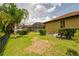 Spacious backyard featuring a pergola, screened-in lanai, manicured hedges, and mature trees at 9852 Caroline Park Dr, Orlando, FL 32832