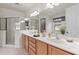 Well-lit bathroom featuring double vanity, large mirror, and glass shower at 9852 Caroline Park Dr, Orlando, FL 32832
