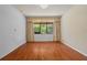 Bright empty room with hardwood floors, neutral tones, and view to outside at 9852 Caroline Park Dr, Orlando, FL 32832