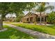 Charming single Gathering home featuring stone accents, manicured lawn, and mature trees at 9852 Caroline Park Dr, Orlando, FL 32832