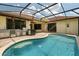 Relaxing pool area featuring a screened enclosure, a built-in outdoor kitchen and water features at 9852 Caroline Park Dr, Orlando, FL 32832