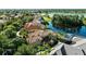 Expansive aerial view showcases the property with its tile roof, a serene lake, and beautifully landscaped surroundings at 1070 Henley Downs Pl, Lake Mary, FL 32746