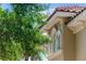 Exterior architectural detail showcasing decorative molding, and windows with a lush tree at 1070 Henley Downs Pl, Lake Mary, FL 32746