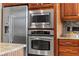 Kitchen with stainless steel refrigerator, microwave, and oven, set against wooden cabinetry at 1070 Henley Downs Pl, Lake Mary, FL 32746