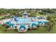 Aerial view of the community pool, showcasing cabanas, lounge chairs, a waterslide, and meticulously landscaped grounds at 1070 Henley Downs Pl, Lake Mary, FL 32746