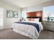 Serene bedroom with a wood headboard, plush bedding, and natural light from two windows at 1114 Cumberland Trail Dr, Lake Hamilton, FL 33851
