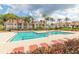 Resort-style pool area with palm trees and plenty of lounge chairs for relaxing by the water at 11526 Westwood Blvd # 735, Orlando, FL 32821