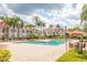 Community swimming pool surrounded by palm trees and lounge chairs at 11526 Westwood Blvd # 735, Orlando, FL 32821