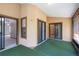 Covered patio featuring two sliding glass doors, a window, and green turf at 1241 Leatherwood Dr, Altamonte Springs, FL 32714