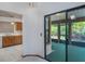 View of an enclosed lanai through sliding glass doors, and a partial view of the kitchen at 1241 Leatherwood Dr, Altamonte Springs, FL 32714