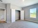 Bedroom with plush carpeting, neutral walls, a window offering outside views, and an open closet at 12885 Sw 43, Ocala, FL 34473