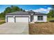 Charming single-story home with a three-car garage, neutral paint, and well-manicured lawn at 12885 Sw 43, Ocala, FL 34473