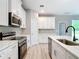 Modern kitchen with stainless steel appliances, quartz countertops, island with breakfast bar, and stylish finishes at 12885 Sw 43, Ocala, FL 34473
