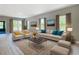 Bright living room featuring stylish furniture, neutral color scheme, and natural light from large windows at 12885 Sw 43, Ocala, FL 34473
