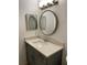 Bathroom vanity with square mirror, round mirror, decorative lighting, and neutral speckled countertop at 14001 Fairway Island Dr # 525, Orlando, FL 32837