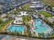 Aerial view of pools, a volleyball court, and lounge seating surrounded by lush landscaping and palm trees at 14826 Deaton Aly, Orlando, FL 32827