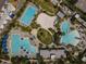 Aerial view of community pools, beach volleyball, and sun loungers with palm trees at 14826 Deaton Aly, Orlando, FL 32827