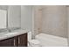 Bathroom featuring a granite vanity with a dark wood cabinet, bathtub, and tile surround at 14826 Deaton Aly, Orlando, FL 32827