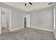 Spacious bedroom with carpeted floors, tray ceiling, and views of the en suite bath and kitchen at 14826 Deaton Aly, Orlando, FL 32827