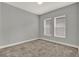 Neutral bedroom features two windows and plush carpeting, providing a cozy and bright space at 14826 Deaton Aly, Orlando, FL 32827