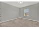 Neutral bedroom features one window and plush carpeting, providing a cozy and bright space at 14826 Deaton Aly, Orlando, FL 32827