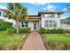 Inviting home exterior showcasing a landscaped front yard with a brick pathway and mature palm tree at 14826 Deaton Aly, Orlando, FL 32827
