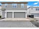 Two-car garage with neutral gray doors and modern exterior lighting fixtures at 14826 Deaton Aly, Orlando, FL 32827
