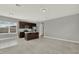 Open-concept living room with dark wood kitchen island, cabinets, and tile and carpet flooring at 14826 Deaton Aly, Orlando, FL 32827