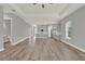 Open concept living room with tray ceilings, modern gray paint, and wood look flooring at 14826 Deaton Aly, Orlando, FL 32827