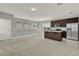 Open-concept room with dark wood kitchen island, stainless appliances, tile and carpet flooring at 14826 Deaton Aly, Orlando, FL 32827
