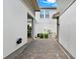 View of a brick-paved side yard area with white walls and minimal landscaping at 14826 Deaton Aly, Orlando, FL 32827